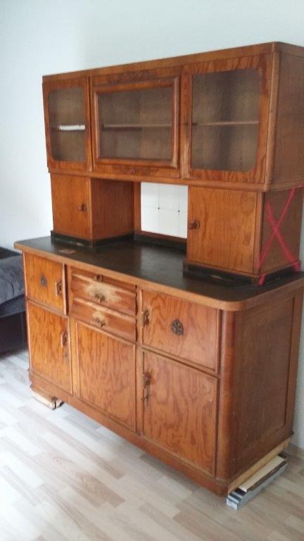 Holzvitrine und Sideboard mit Glastüren in einem Raum mit hellem Holzboden.