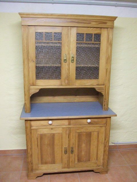 Zweiteiliges Holzschrank-Set mit grauer Arbeitsplatte, auf einem gefliesten Boden an einer Wand.