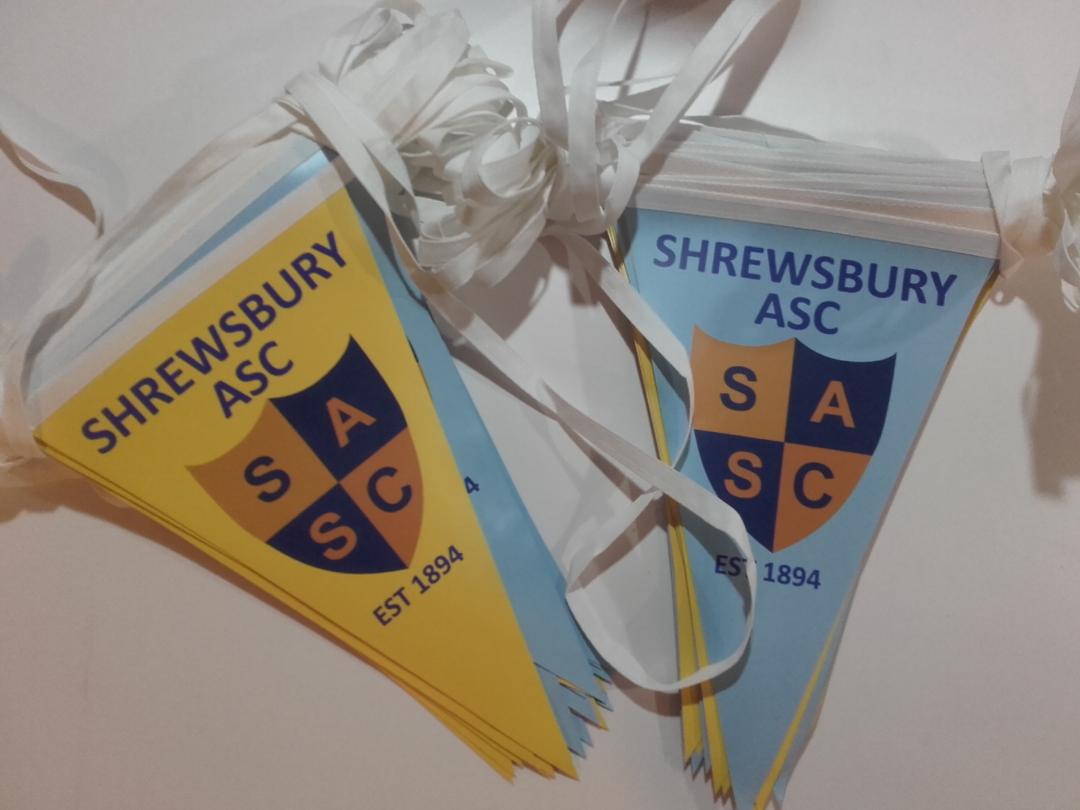 To Shrewsbury ASC-flag ligger på et bord
