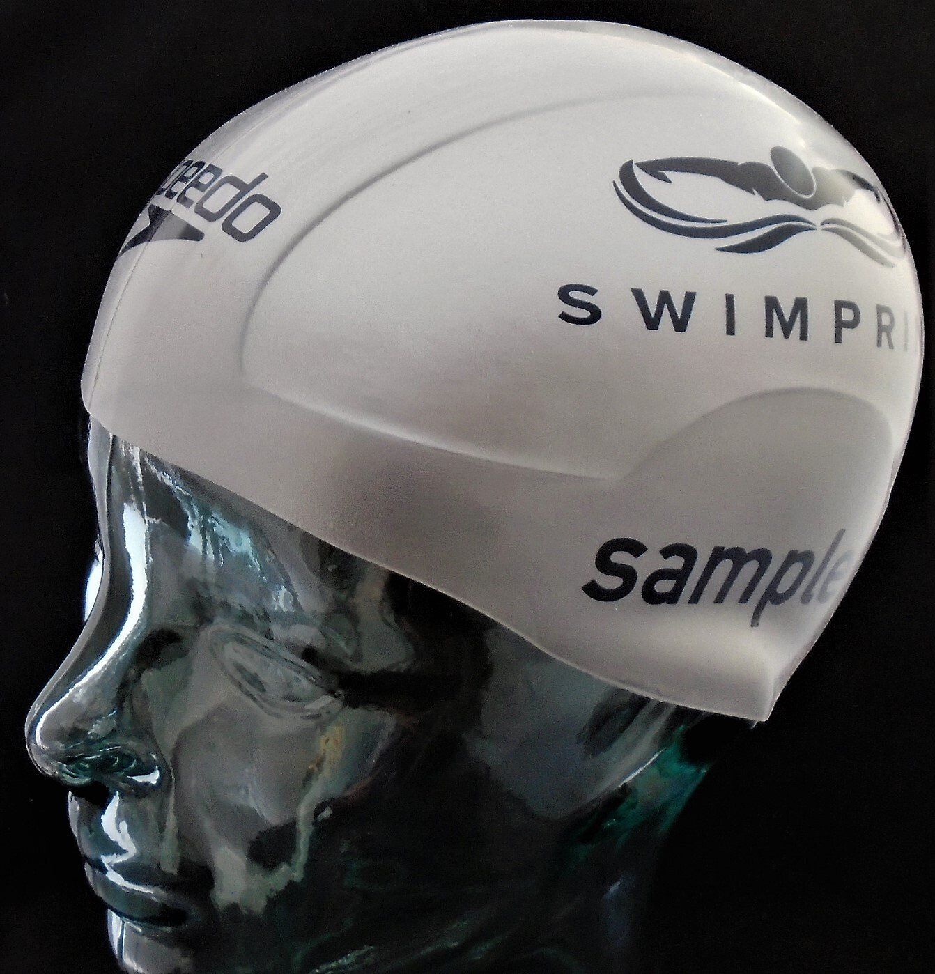 A white speedo swim cap is on a mannequin head