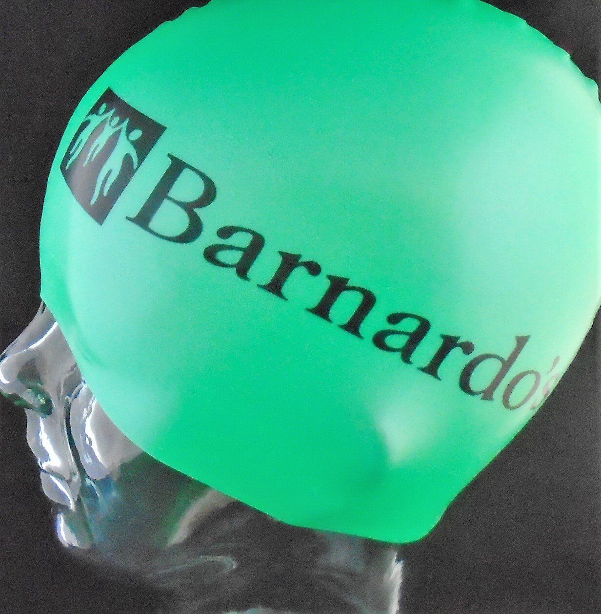 A green swimming cap that says barnardo on it
