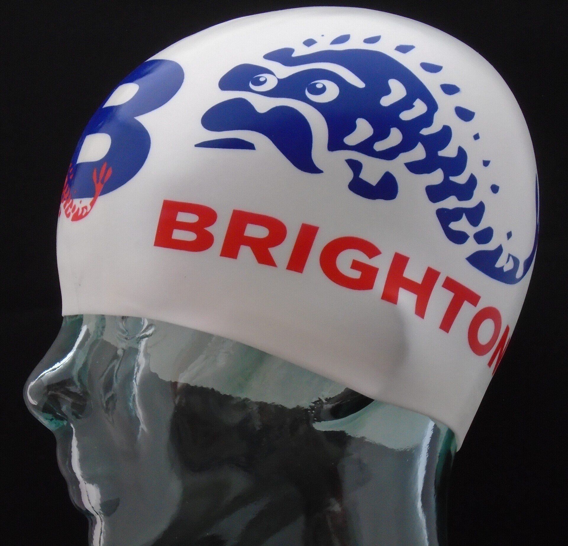 A white swim cap that says brighton on it