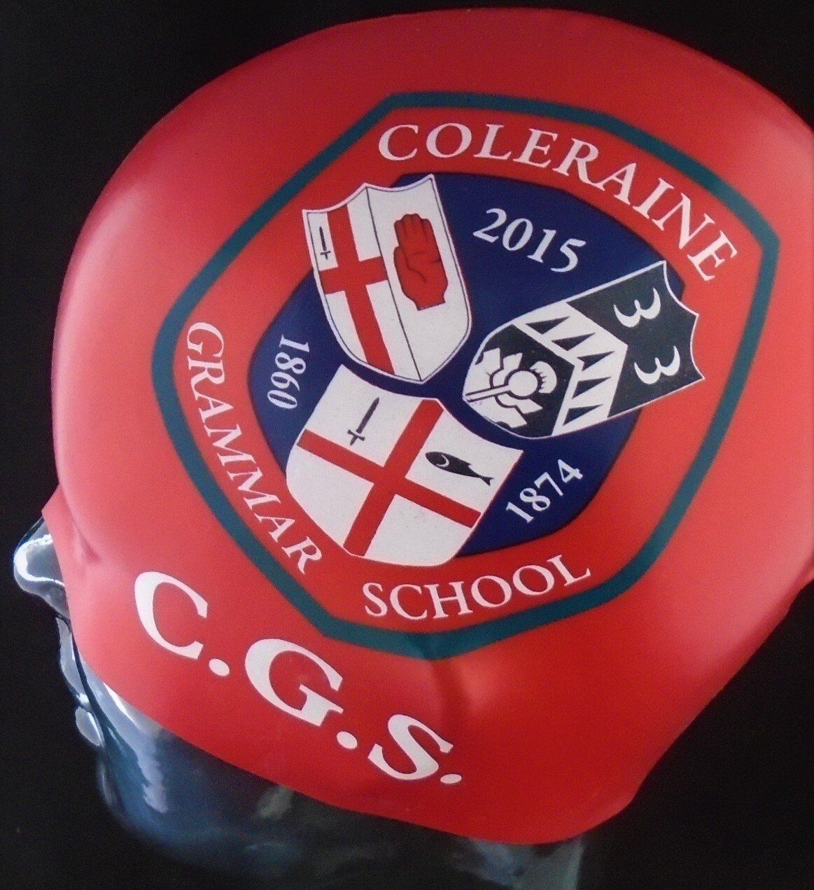 A red c.g.s. swim cap with a crest on it