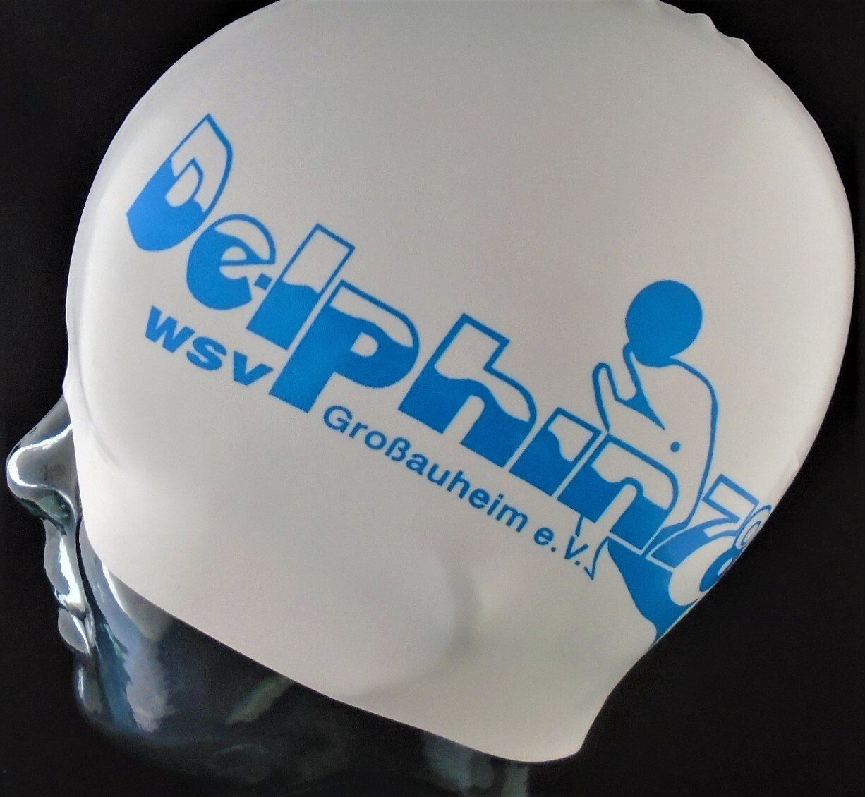A white swim cap with the word dolphin on it
