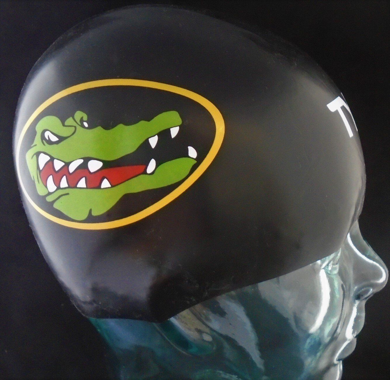 A black swim cap with a crocodile on it