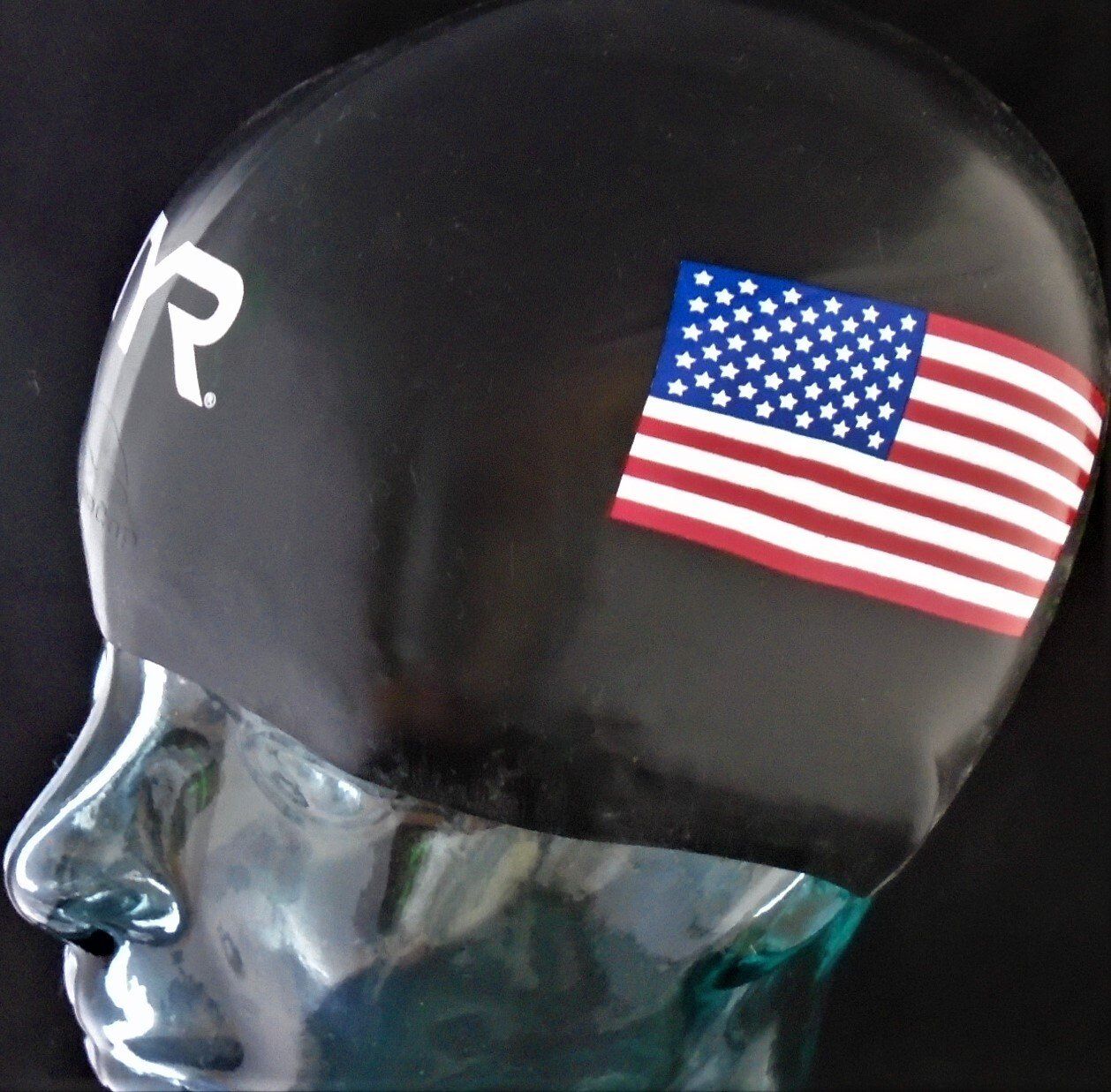 A black swim cap with an american flag on it