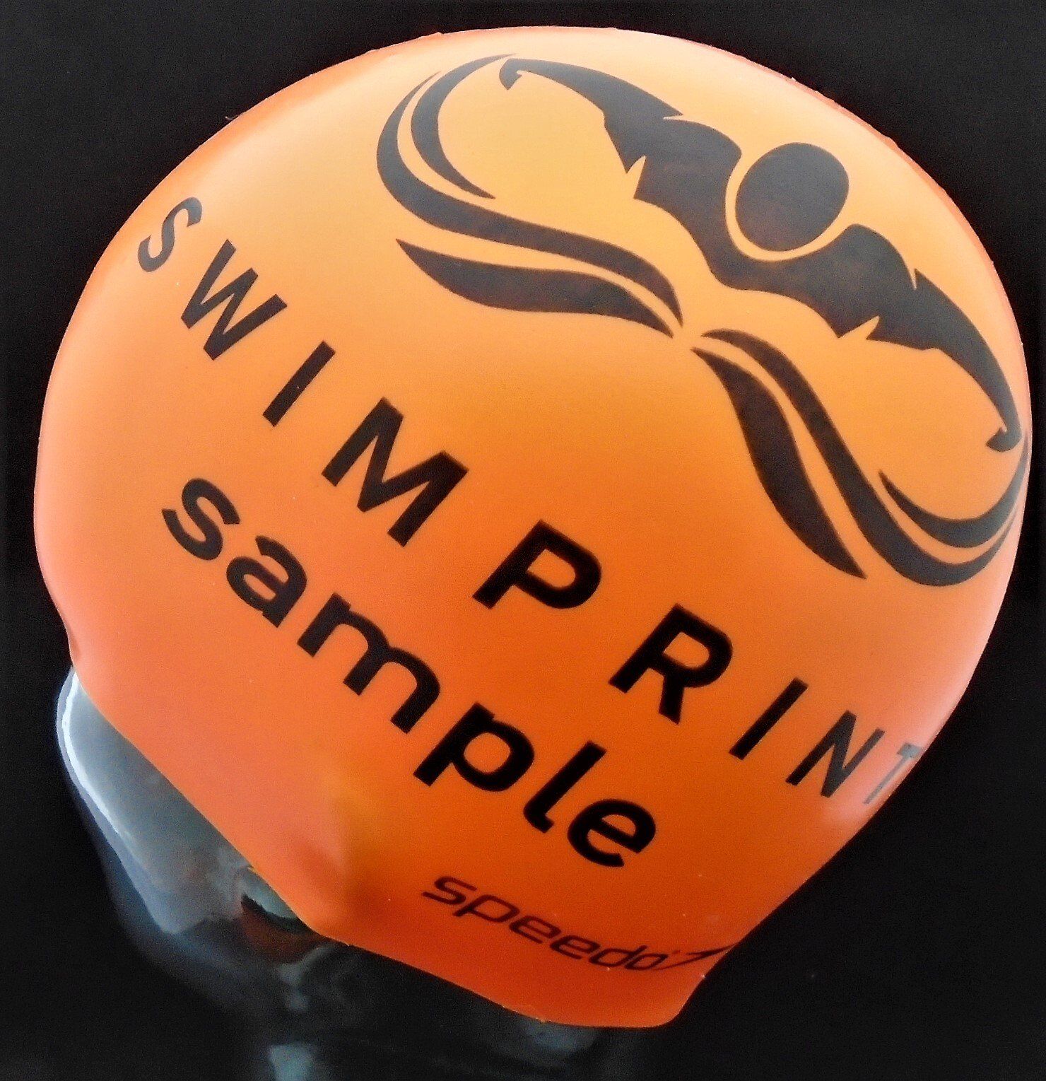 An orange swim cap that says swim print sample on it