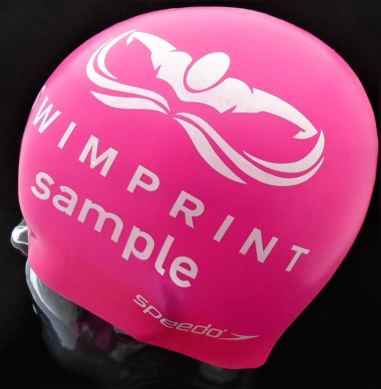 A pink swim cap that says wimp print sample on it