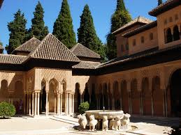 There is a fountain in the middle of the courtyard of a building in the Alhambra palace.