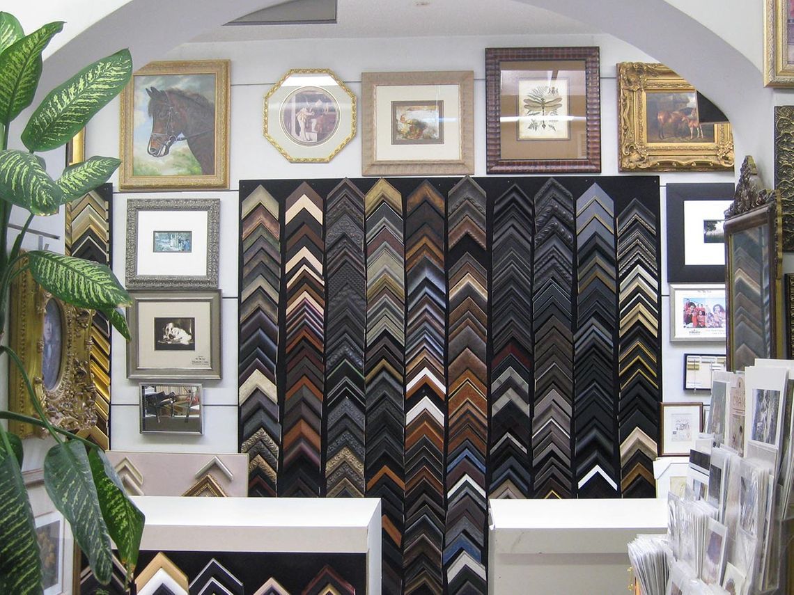 Art gallery with framed pictures and a wall display of various frame styles.