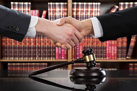 Stretta di mano tra due uomini con una libreria sullo sfondo