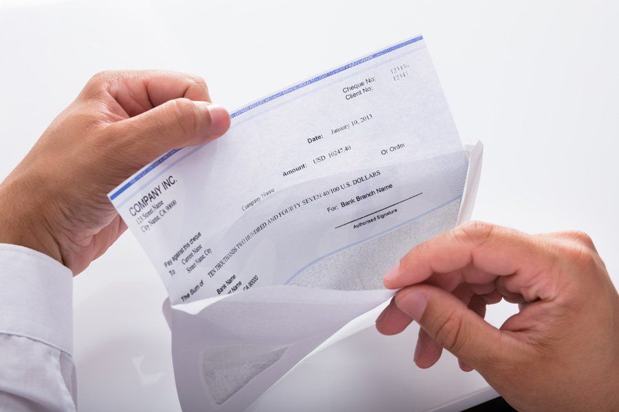 Opening Envelope With Paycheck — Houston, TX — IRS Tax Fighters
