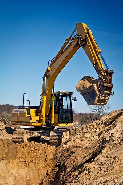 A front loader digs a hole on a construction site.