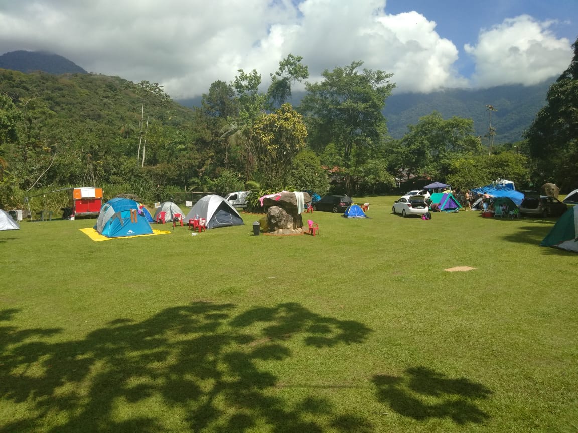 Um grupo de tendas está montado em um campo gramado