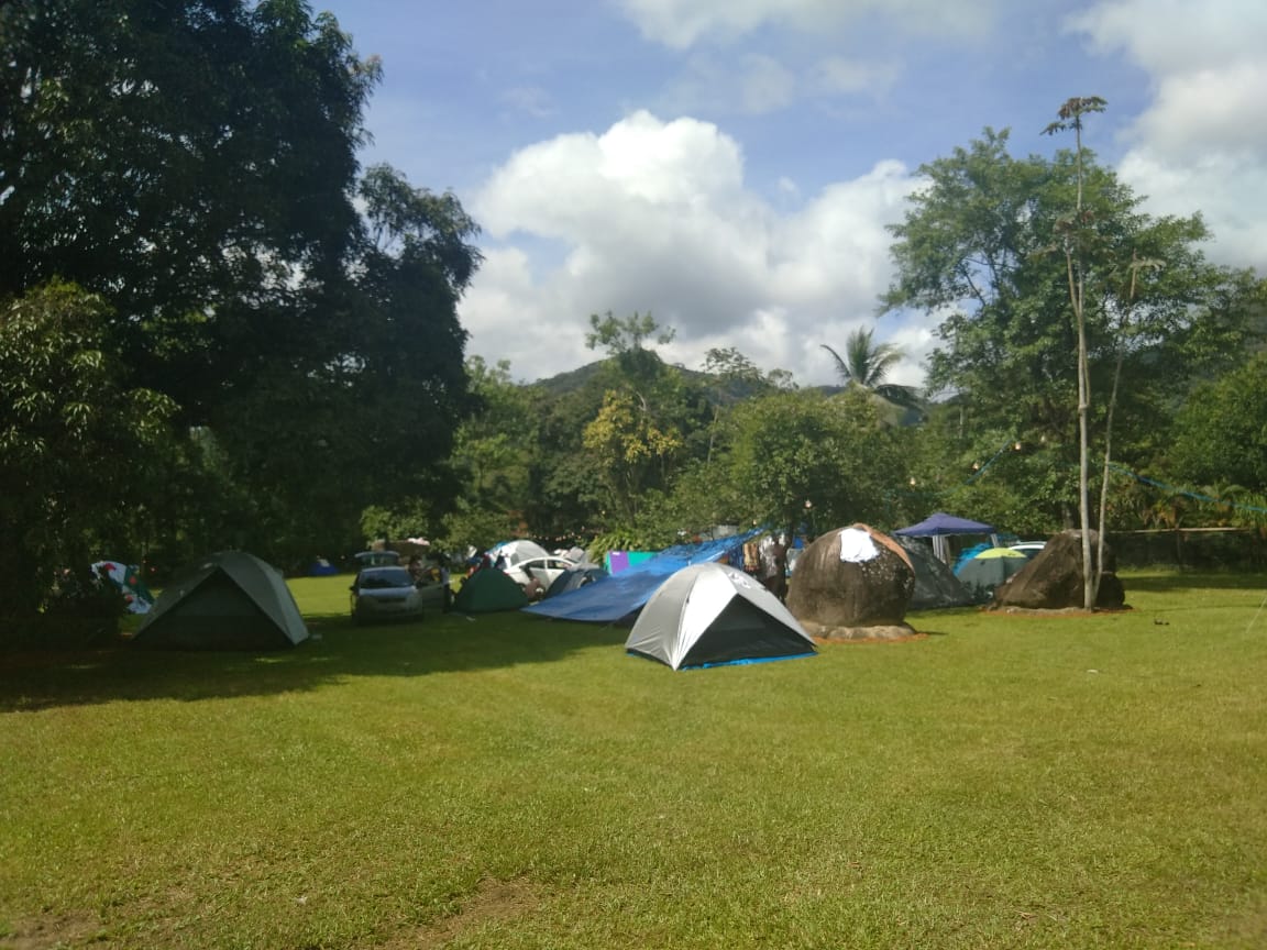Um grupo de tendas está montado em um campo gramado
