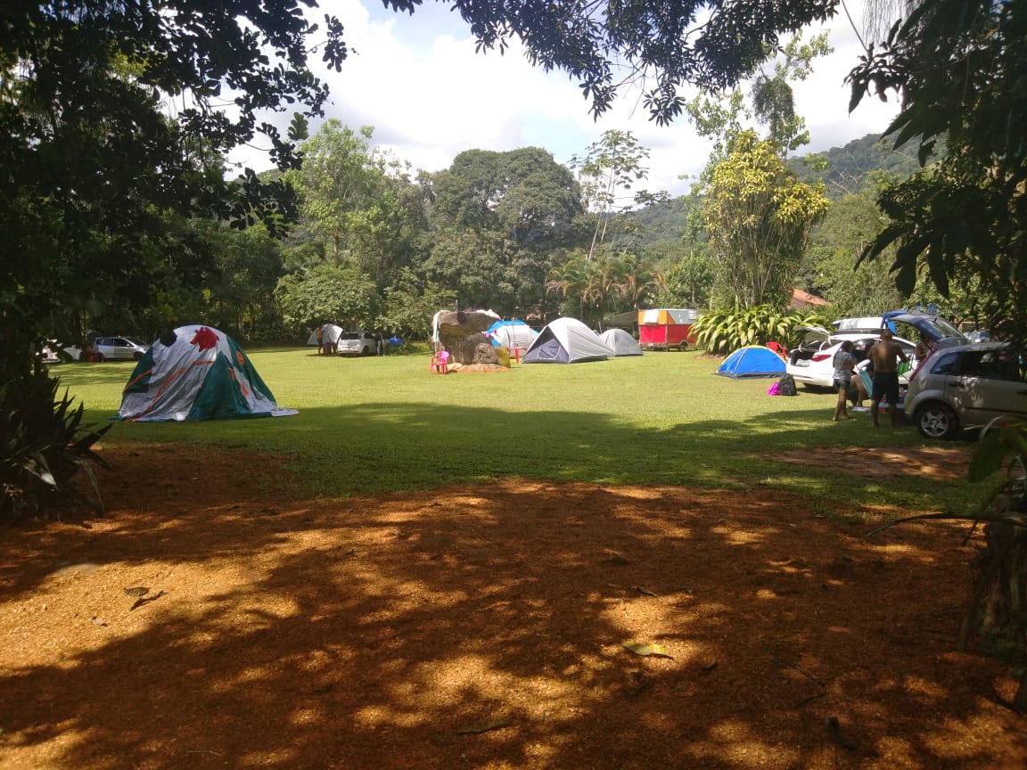 Um grupo de tendas está montado em um campo gramado