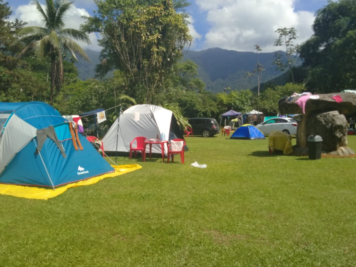 Um grupo de tendas está montado em um campo gramado
