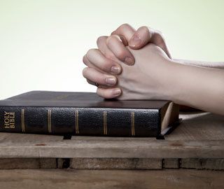 praying hands with bible