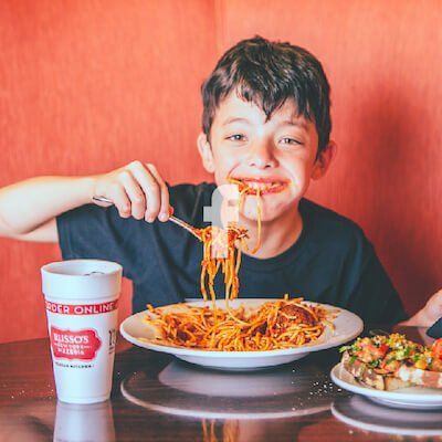 Kid Eating with Facebook Logo White