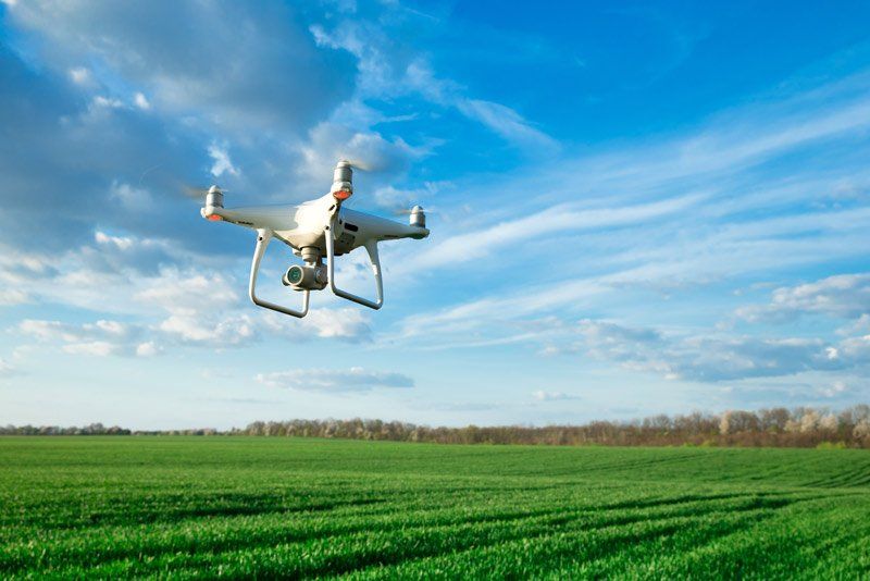 A drone is flying over a green field.