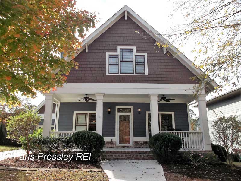 A house with a large porch and a sign that says pressley re