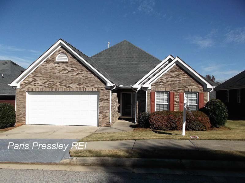 A brick house with a white garage door is for sale by maris pressley rei