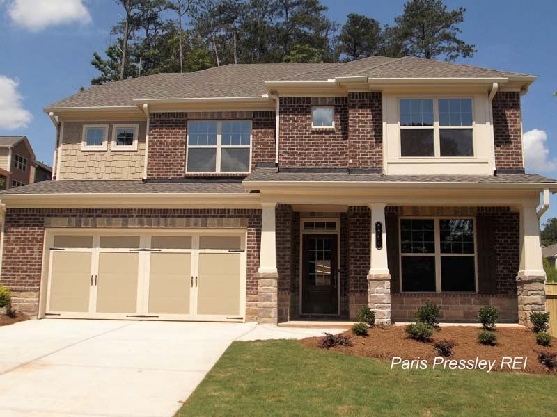 A large brick house with a tan garage door