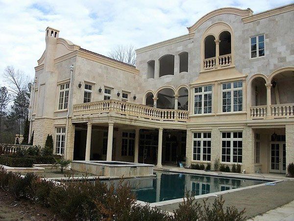 A large house with a swimming pool in front of it