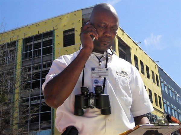 A man wearing binoculars is talking on a cell phone