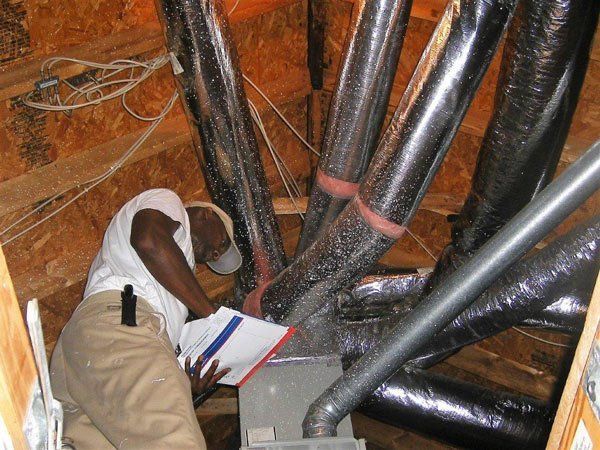 A man is looking at a piece of paper in a room filled with pipes