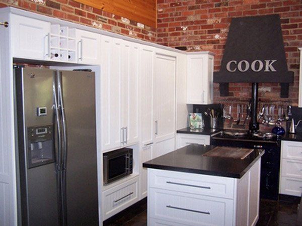 modern kitchen with white cupboards and black granite