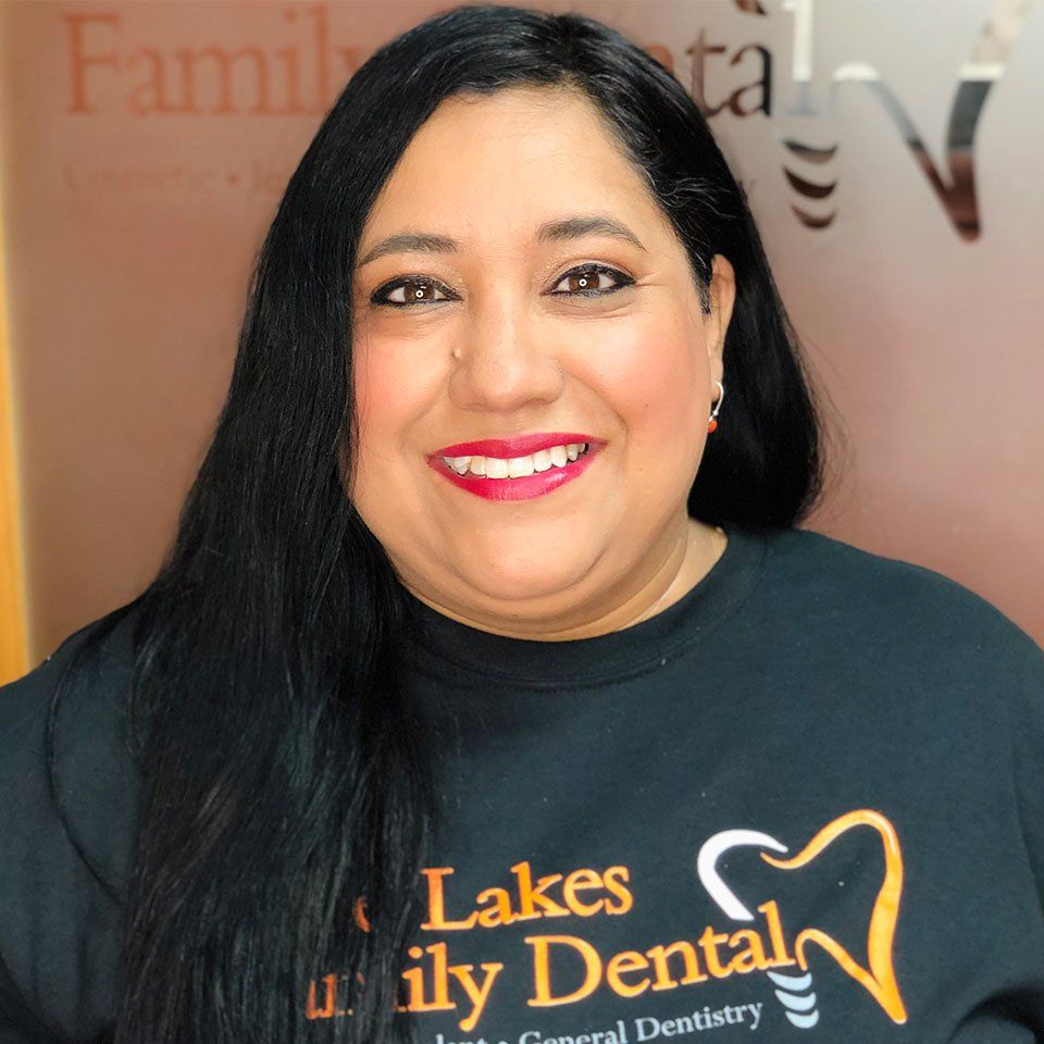 A woman wearing a black shirt that says lakes family dental