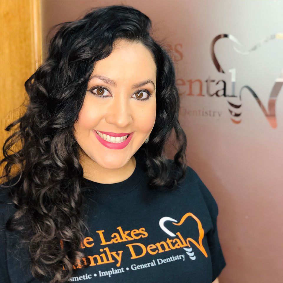 A woman wearing a black shirt that says lakes family dental