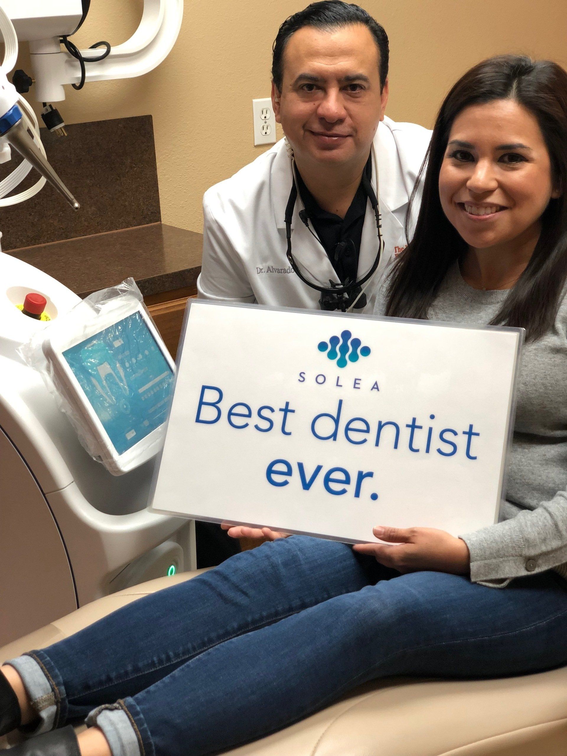 A woman is holding a sign that says best dentist ever