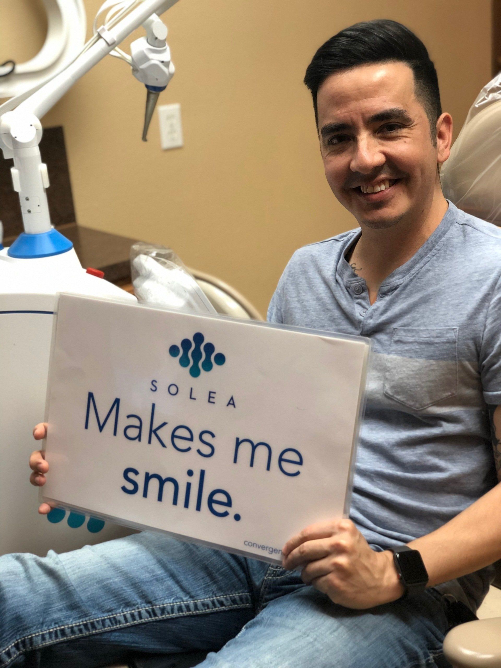 A man holding a sign that says solea makes me smile