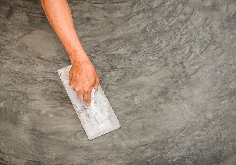 Man Applying Cement on The Floor — Jamestown, NC — Decorative Concrete Unlimited Inc