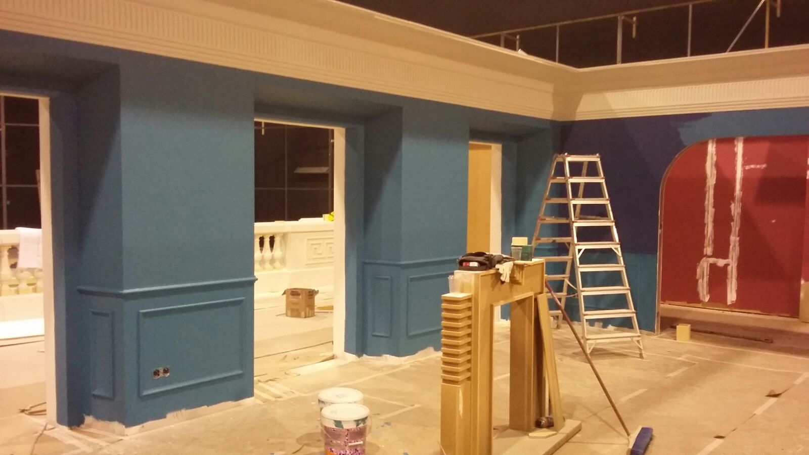 Una habitación con paredes azules y rojas y una escalera.