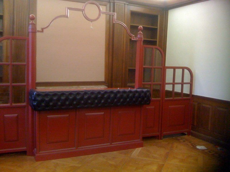 Una habitación con paredes rojas y un sofá negro.