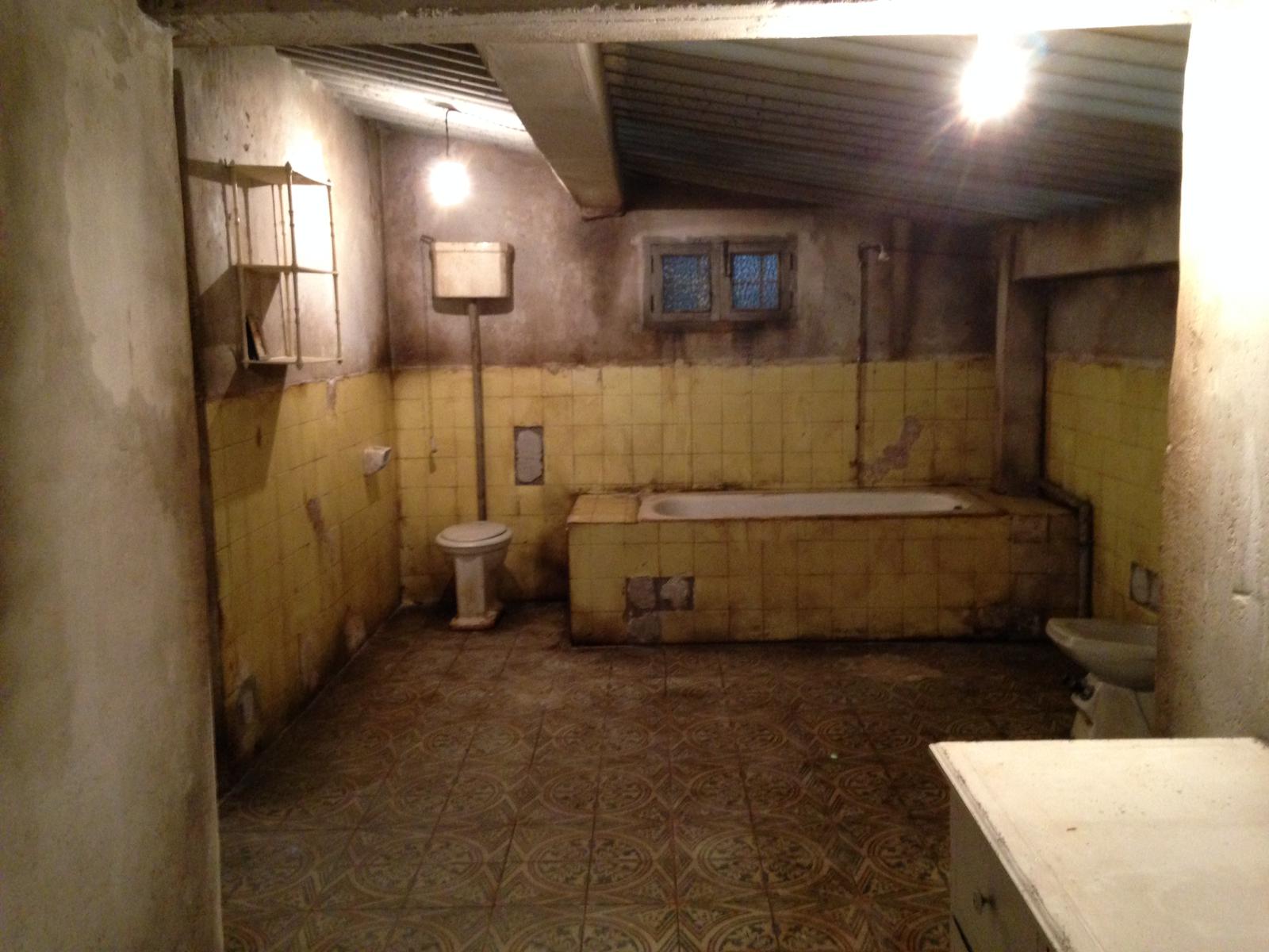 Un baño con azulejos amarillos y una bañera.