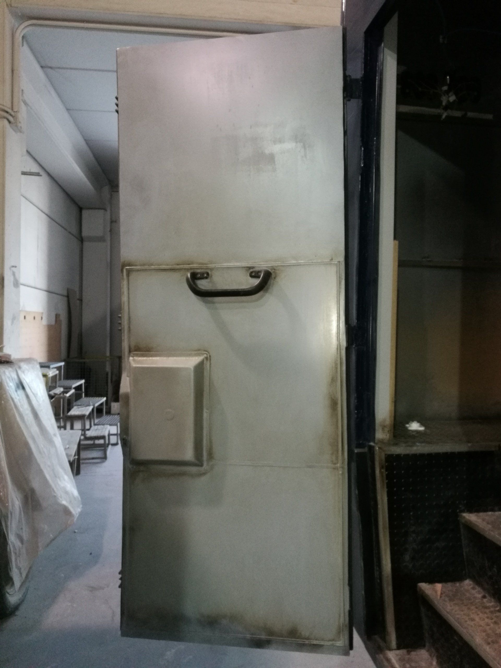 Una gran puerta de metal con tirador en una habitación.