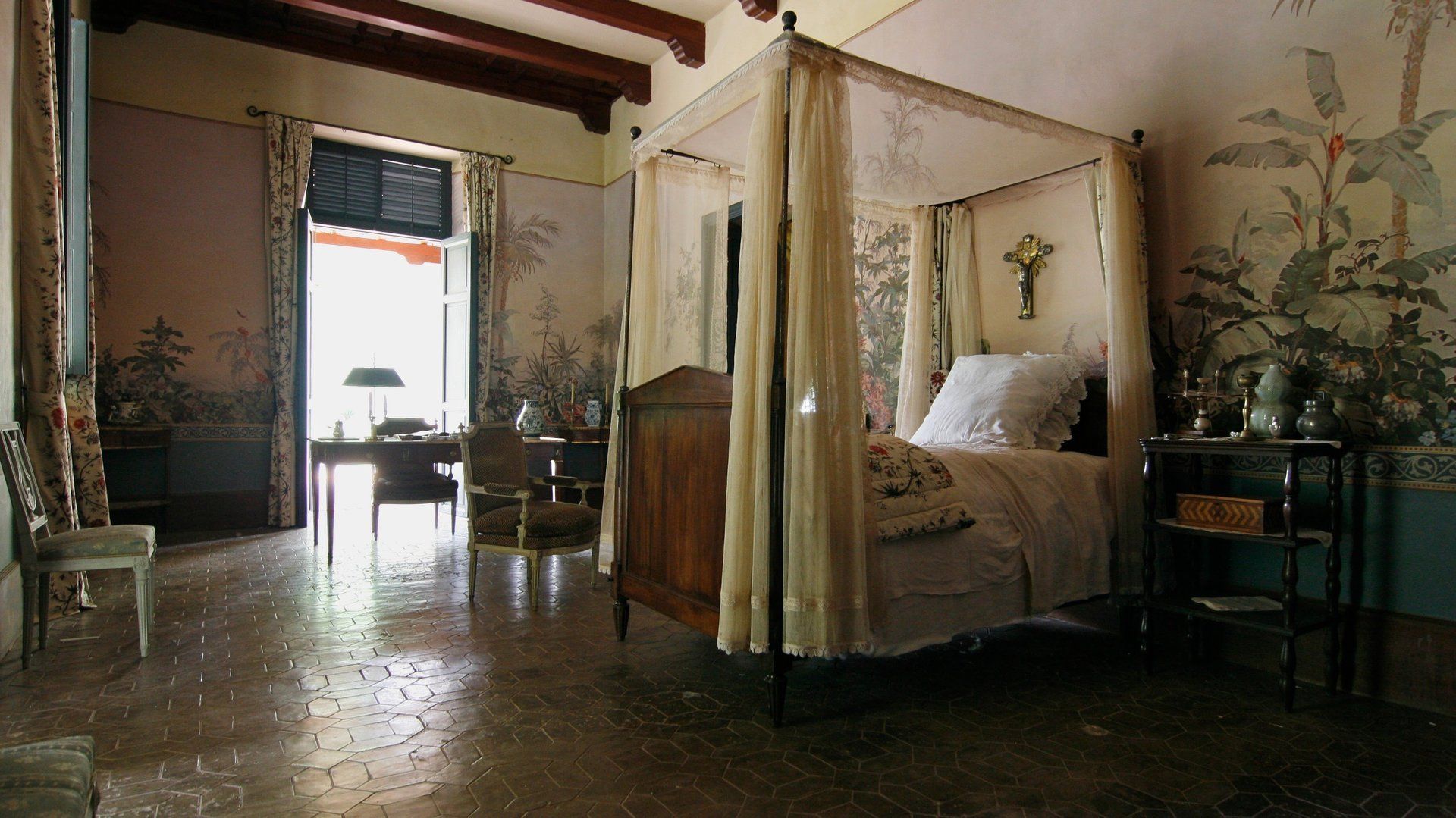 Un dormitorio con una cama con dosel y un escritorio.