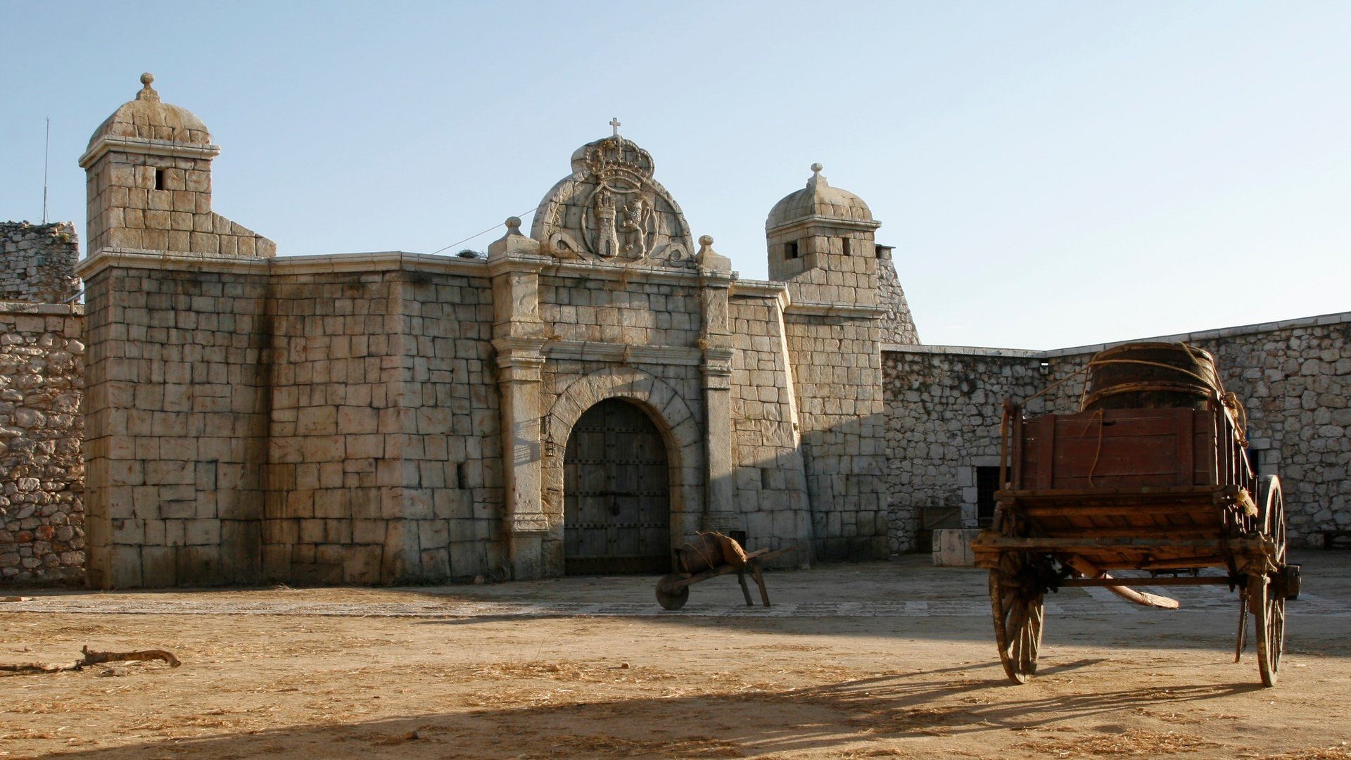 Un carruaje tirado por caballos está estacionado frente a un edificio de piedra.