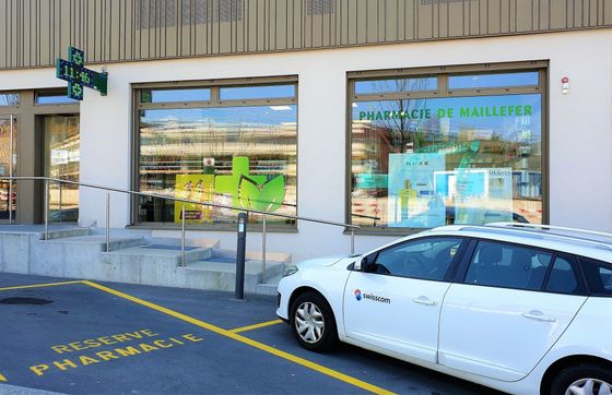 Place de parking et vitrine de la Pharmacie de Maillefer