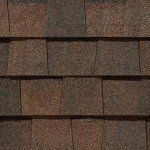 Brown composite roof shingles with varying shades, close-up view.