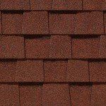 Red-brown asphalt roof shingles in a close-up, overlapping pattern.