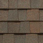 Close-up of brown asphalt roof shingles with a textured appearance.