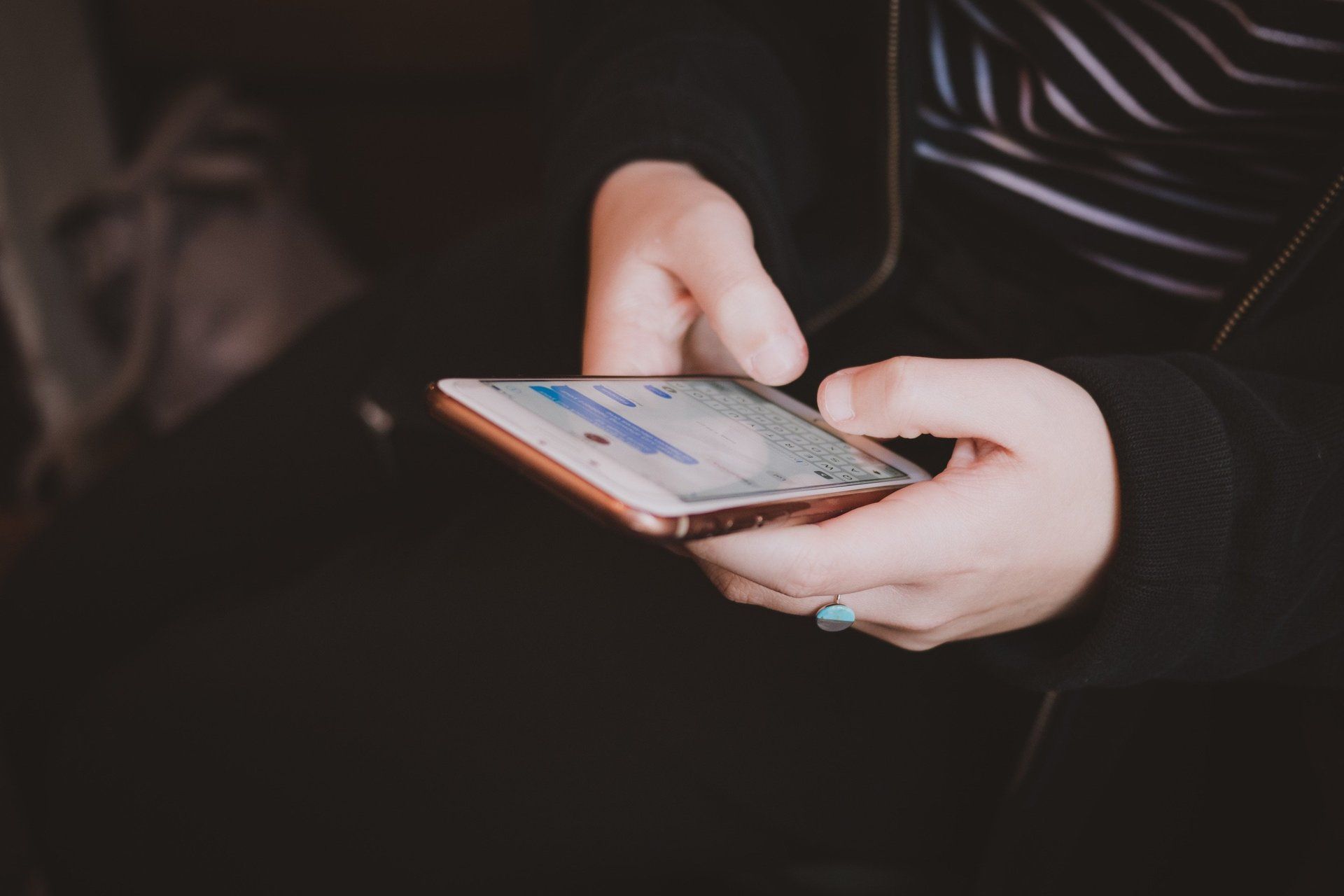 A person is holding a cell phone in their hands.