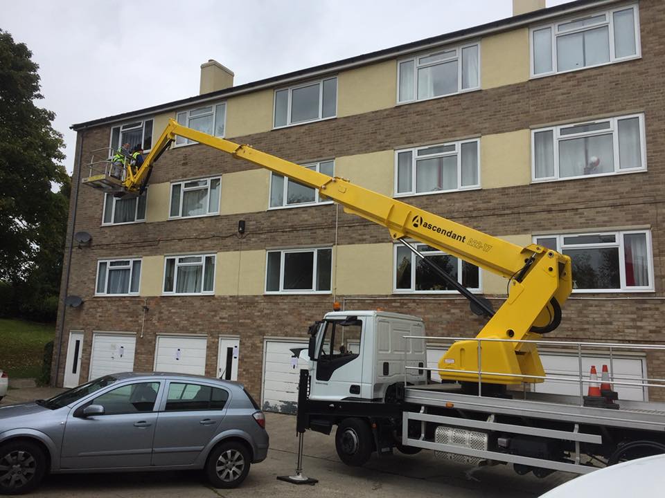 Cherry picker accessing third floor window on residential block of flats