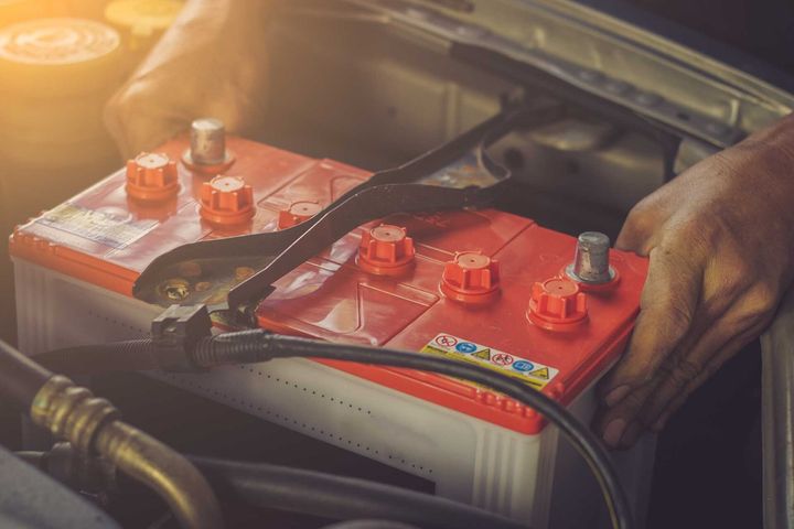 Man Holding a Red Car Battery — Car Battery Replacement in South Lismore, NSW Man Holding a Red Car Battery — Car Battery Replacement in South Lismore, NSW