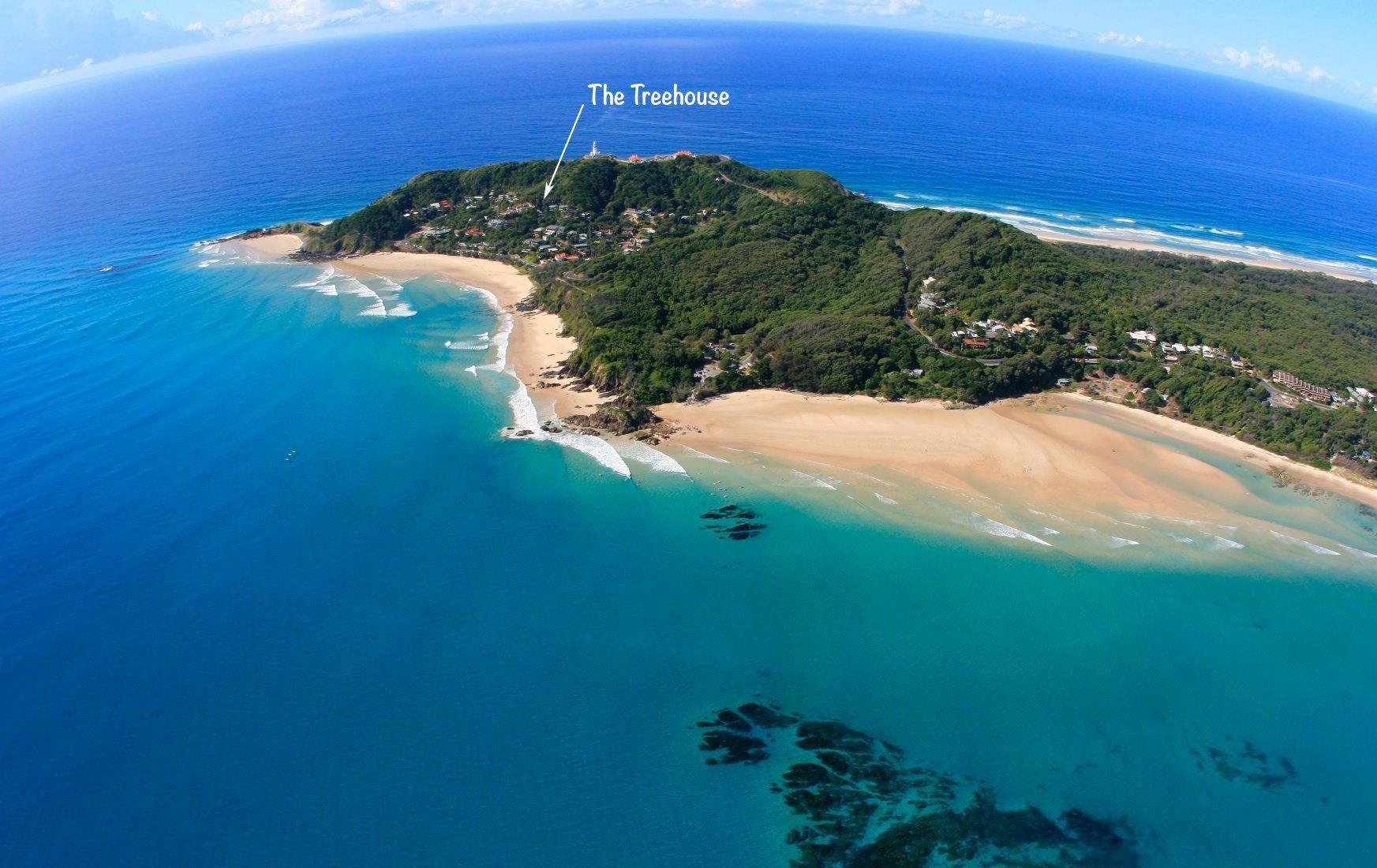 Aerial view of a small tropical island with sandy beaches, turquoise water, and dense green vegetation